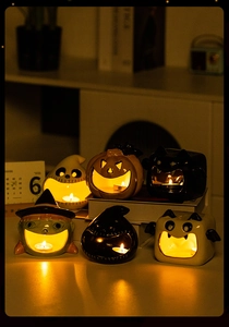 Cozy Halloween ceramic tea light holders with pumpkin and ghost motifs in warm candlelight