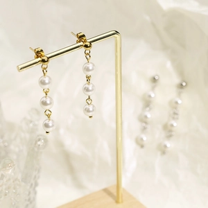Boucles d'oreilles pendantes dorées avec trois perles en cascade sur fil métallique
