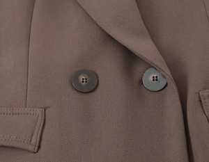 Détail des boutons croisés et du revers d'un blazer cintré pour femme marron café