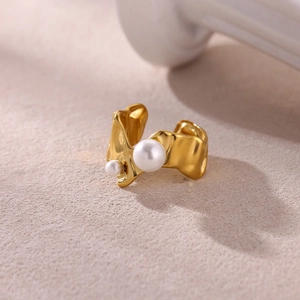 Macro shot of 18k gold plated ring featuring irregular lava texture and twin pearls