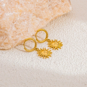 Detail of 18k gold plated stainless steel sun pendant earrings with detailed face