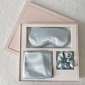 Detail of light blue silk sleep set including eye mask, pillowcase and scrunchie in gift box