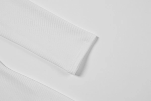 Gros plan détaillé des poignets côtelés élastiques d'une robe blanche à manches longues