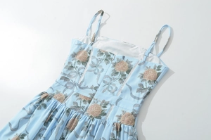 Dettaglio dell'abito a fiori azzurro con motivi di rose vintage e cerniera lampo invisibile