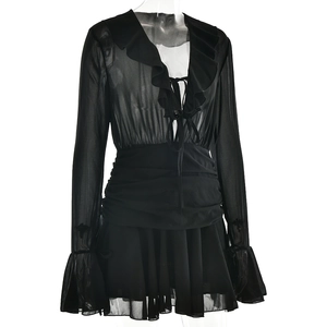 Detail of deep V-neckline with ruffled edges and drawstring on a black chiffon dress