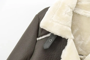 Close-up of dark brown leather jacket featuring thick off-white sherpa lining on collar