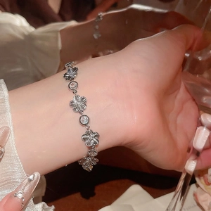 Élégant bracelet fleur en argent avec oxydes de zirconium au poignet d'une femme