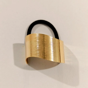 Detailed view of golden seven-petal flower hair accessory with brushed metal texture
