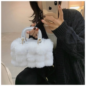 Detailed close-up of a white plush faux fur tote bag with leather handle and gold hardware