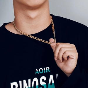 Close-up of golden stainless steel NK chain necklace worn by a male model for hip hop style