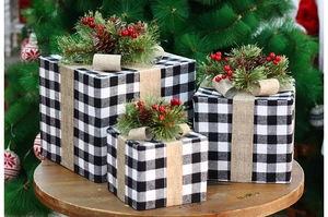 Lot de trois boîtes de Noël à carreaux avec pommes de pin et baies sur un socle en bois