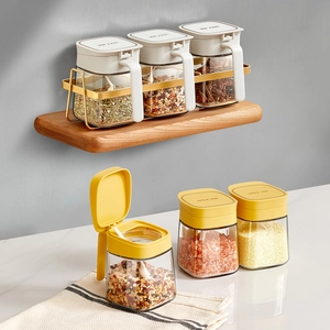 Set of 3 glass spice jars with handles on a gold metal rack for kitchen organization