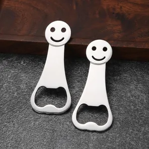 Detail showing two smiley face stainless steel bottle openers on a dark stone surface