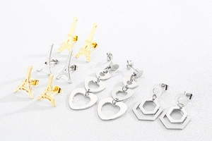 Détail de boucles d'oreilles en acier inoxydable en formes de pyramide, cœur et hexagone