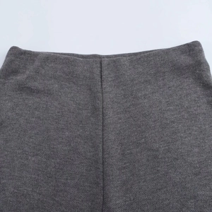 Primer plano detallado de la textura de punto gris y costuras de la camiseta de mujer