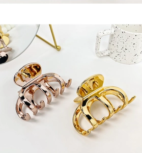 Detail of elegant gold and rose gold metal claw clips for hair styling on white background