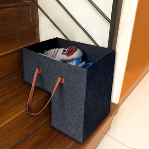 Grey felt L-shaped stair storage basket with brown leather handles on wooden steps