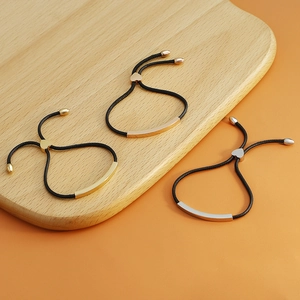Three minimalist braided rope bracelets with polished curved metal bars in three finishes