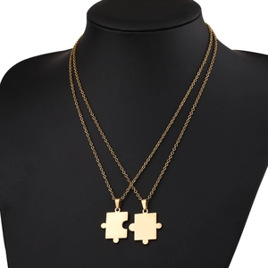 Matching gold-plated stainless steel puzzle pendant necklaces for couples on black mannequin