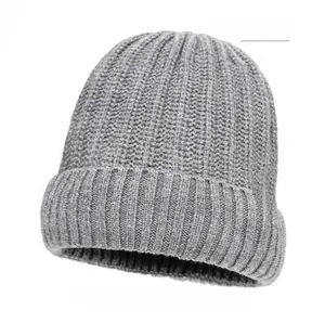 Detailed view of light gray knit beanie showing classic ribbed texture and leather patch