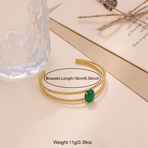 Detail of twisted gold bangle with oval green stone inlay and sizing measurements