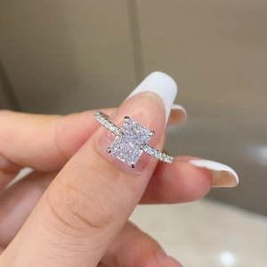 Macro shot of silver ring with radiant square gemstone and petite side diamonds