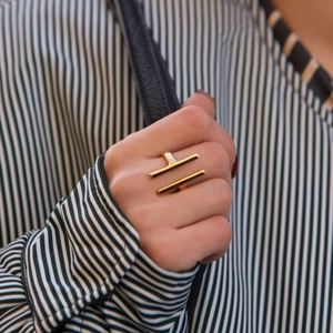 Close-up of minimalist gold geometric parallel bar ring worn on model's hand
