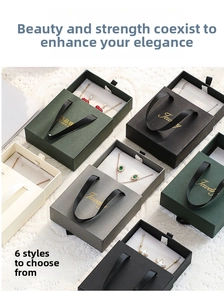 Detail of drawer-style jewelry boxes with ribbon handles and textured paper finish