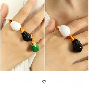 Detailed view of exaggerated gold ring with large white, black and green teardrop enamel
