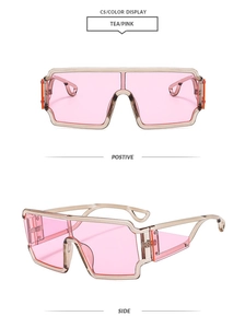 Detail view of retro square pink sunglasses with oversized lenses and tea-colored frames