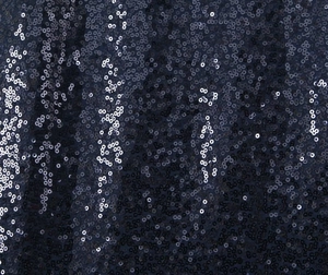 Close-up of deep blue sequins and mesh fabric on a sleeveless backless party dress