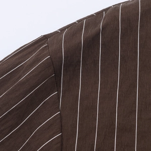 Détail rapproché d'une chemise en popeline marron foncé à fines rayures blanches