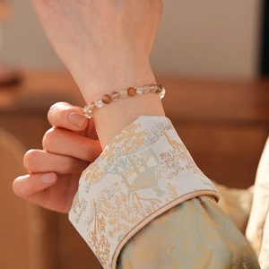 Elegant multi-color beaded bracelet with clear and amber stones on model's wrist