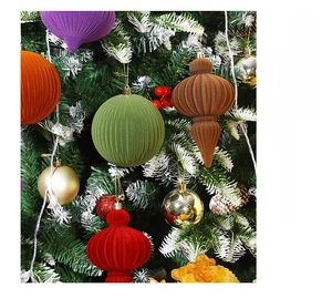 Close-up of velvet flocked gourd-shaped Christmas ornaments hanging on a pine tree