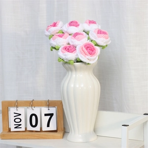 Handmade crochet rose bouquet in pink and white yarn, styled in a ceramic vase