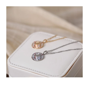 Pink western cowboy hat pendants on gold and silver necklaces displayed in a gift box