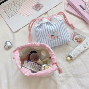 Détail d'un sac de rangement à rayures bleues avec dentelle et cordon pour maquillage