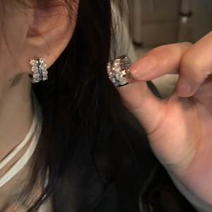 Close-up of silver hoop earrings with multiple rows of sparkling zircon pavé