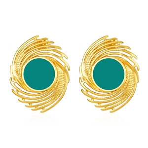 Detailed view of vintage gold spiral earrings with green center enamel and textured patterns