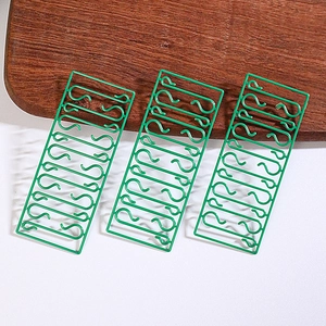 Close-up of green S-shaped hooks for Christmas tree ornaments in three-panel packaging
