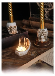 Macro shot of gothic resin skeleton hand and skull candle holders for Halloween decor