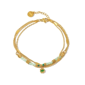 Detail of layered gold stainless steel bracelet with green beads and evil eye pendant