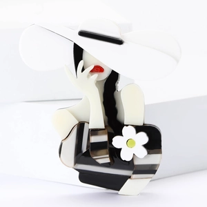 Detailed macro shot of acrylic lady brooch with white flower on minimal white stand