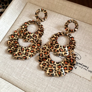 Detail view of vintage leopard print layered earrings with gold scalloped metal edges
