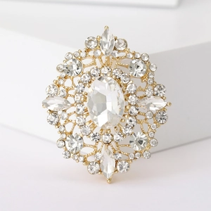 Detail of vintage gold oval brooch with intricate filigree and sparkling clear crystals