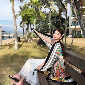Outdoor lifestyle shot of a large bohemian paisley print shawl with black border and silk texture
