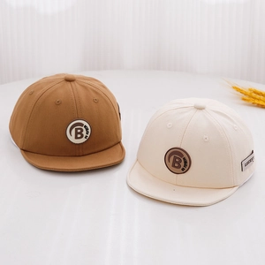 Detail view of cotton kids baseball caps with letter B patch in khaki and cream white