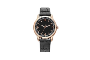 Close-up of rose gold watch case with black dial and embossed crocodile leather strap