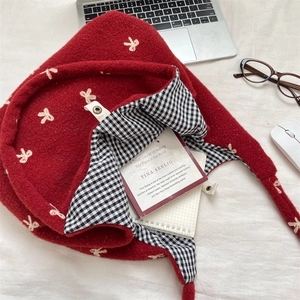 Macro view showing the embroidered bow details and spacious plaid lining of the tote bag
