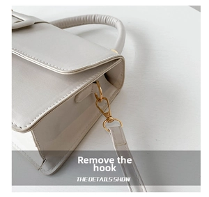 Detailed close-up of white PU leather bag with golden hardware hooks and detachable strap